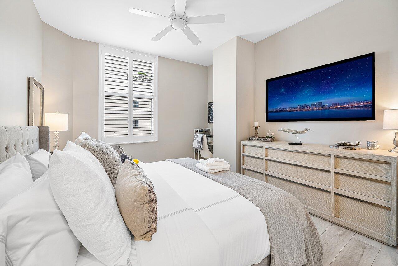 255 Evernia Street, Unit 1502 West Palm Beach, FL 33401 - Photo 16 of 40 a bedroom with a bed and a flat screen tv