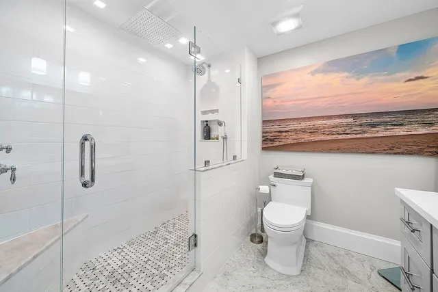 a bathroom with a toilet a sink and a large mirror