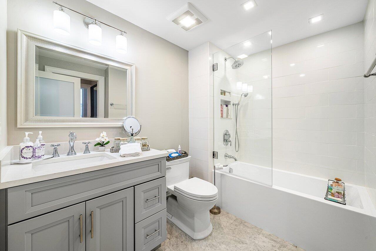 255 Evernia Street, Unit 1502 West Palm Beach, FL 33401 - Photo 21 of 40 a bathroom with a double vanity sink toilet mirror and shower
