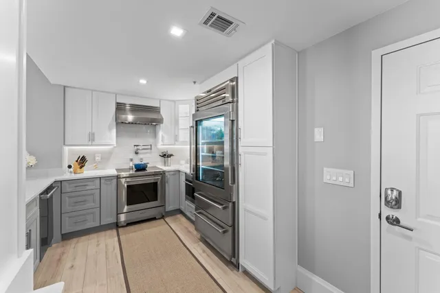 a kitchen with stainless steel appliances a stove and cabinets