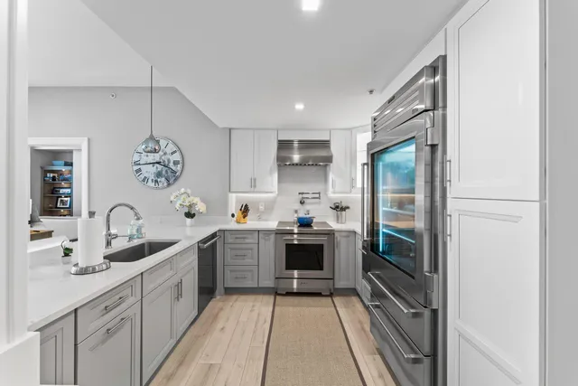 a kitchen with stainless steel appliances granite countertop a sink stove and cabinets