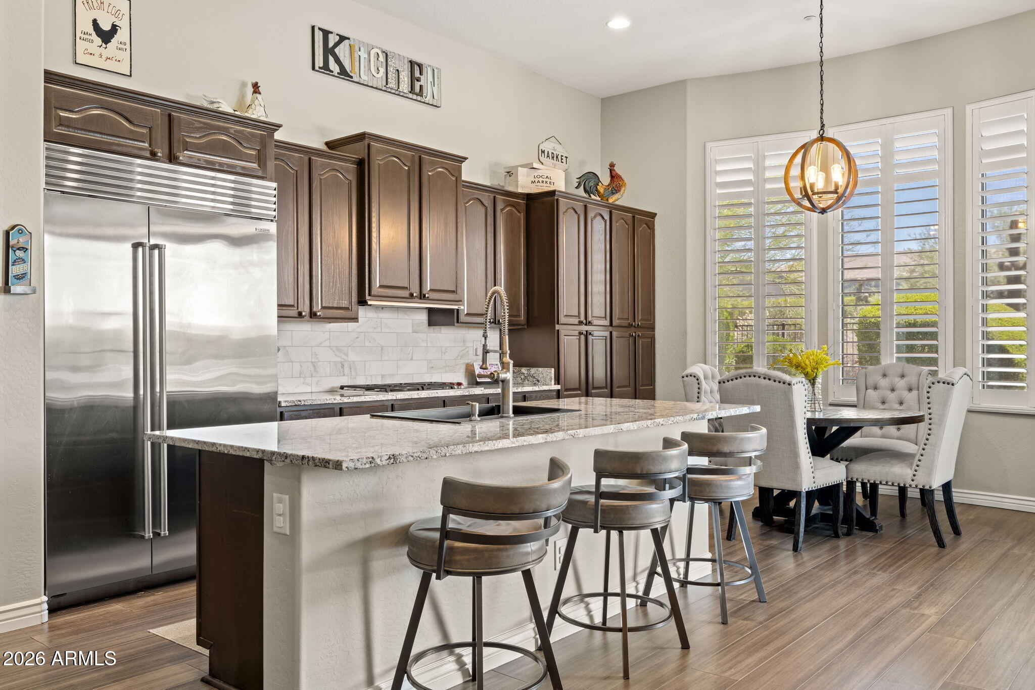 41619 North River Bend Road Anthem, AZ 85086 - Photo 49 of 84 a kitchen with stainless steel appliances granite countertop a stove a refrigerator a kitchen island a table and chairs
