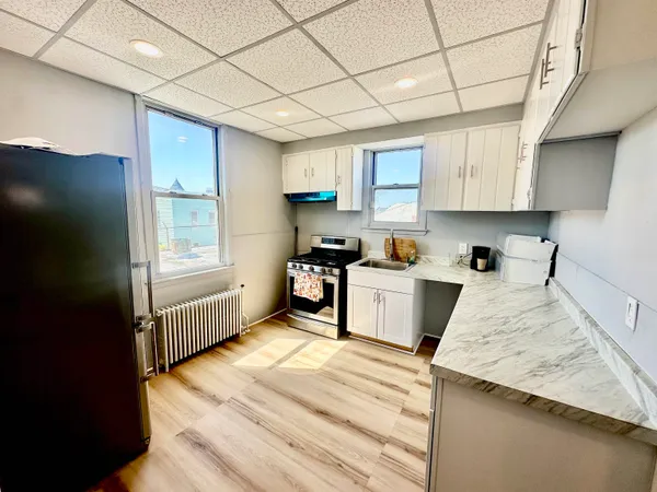 a kitchen with granite countertop white cabinets and stainless steel appliances