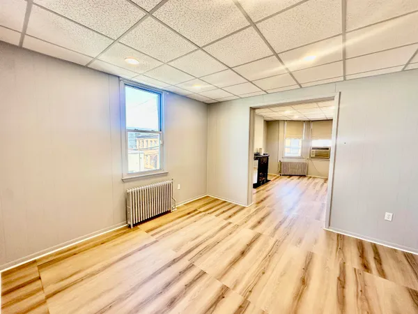 a view of empty room with wooden floor