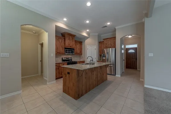 a large kitchen with stainless steel appliances lots of counter space and a sink