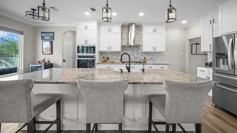 a kitchen with kitchen island granite countertop a sink and stainless steel appliances