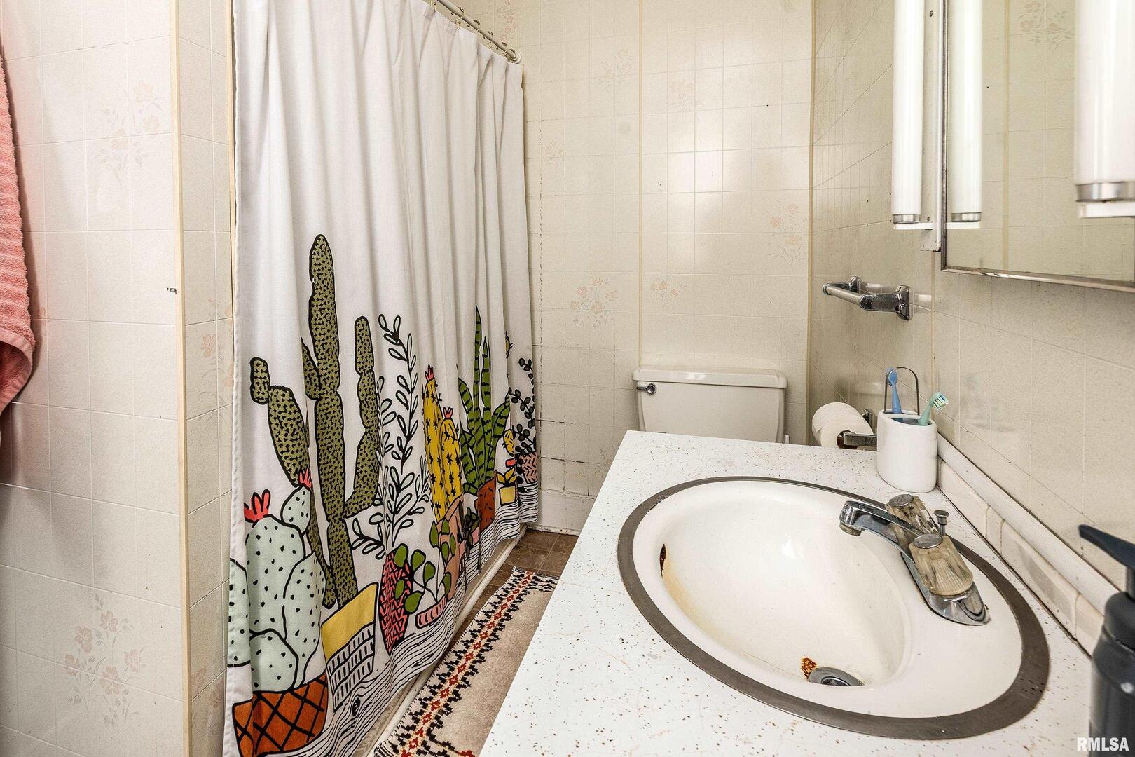 501 South Buchanan Street Marion, IL 62959 - Photo 17 of 32 a bathroom with a sink a mirror and a bathtub