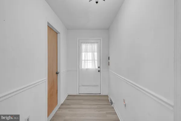 a view of a hallway with wooden floor and closet