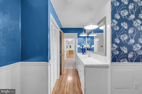 walk in closet with wooden floor and chandelier