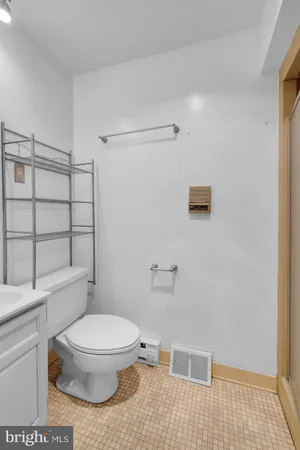 a white toilet sitting next to a shower