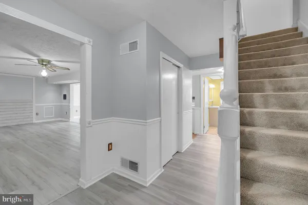 a view of a hallway with wooden floor and staircase