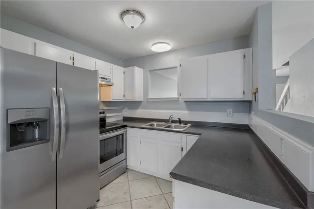 a kitchen with stainless steel appliances granite countertop a refrigerator and a stove top oven
