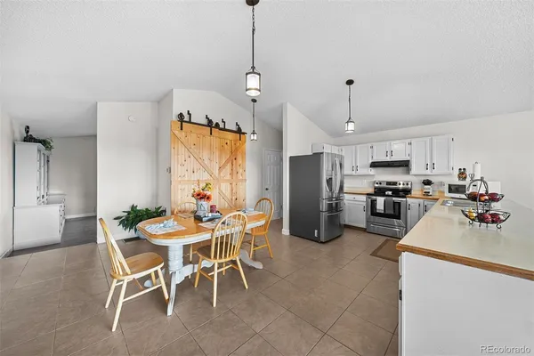 a view of a dining room and livingroom with furniture wooden floor a chandelier