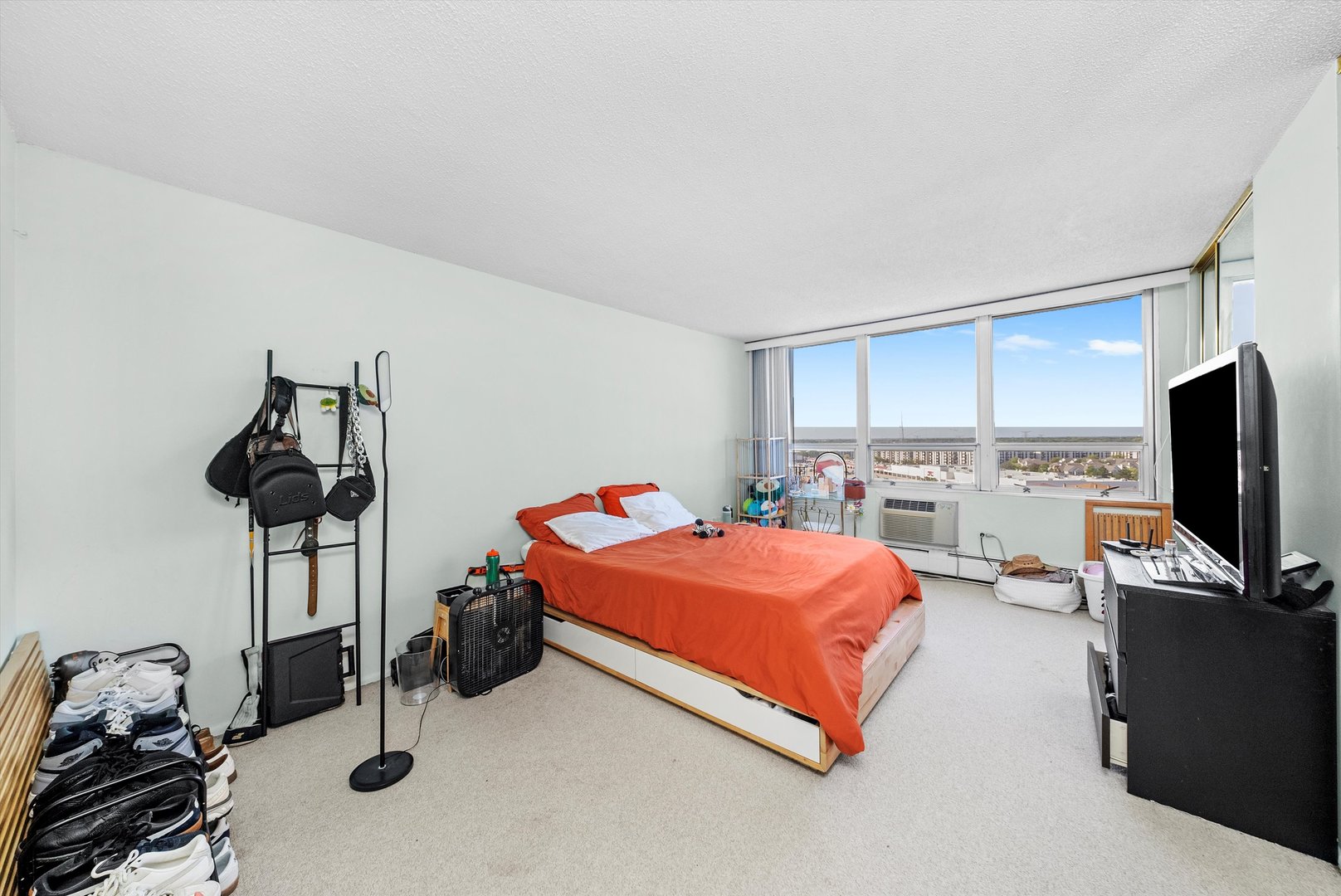 8815 West Golf Road, Unit 11C Niles, IL 60714 - Photo 18 of 31 a bedroom with a bed and a flat tv screen on the wall