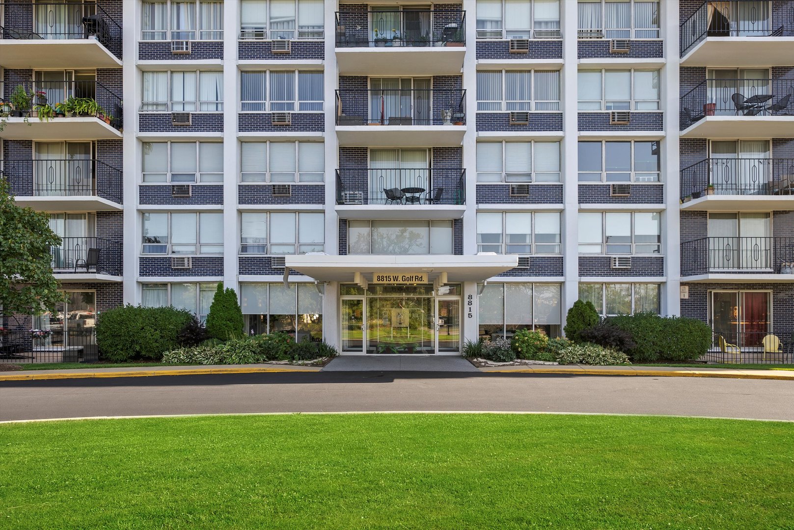 8815 West Golf Road, Unit 11C Niles, IL 60714 - Photo 2 of 31 a front view of a residential apartment building with a yard