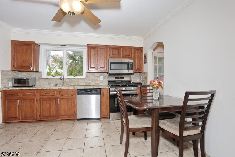 12 Pershing Avenue Ridgewood, NJ 07450 - Photo 11 of 42 a kitchen with stainless steel appliances granite countertop a stove top oven a sink a dining table and chairs