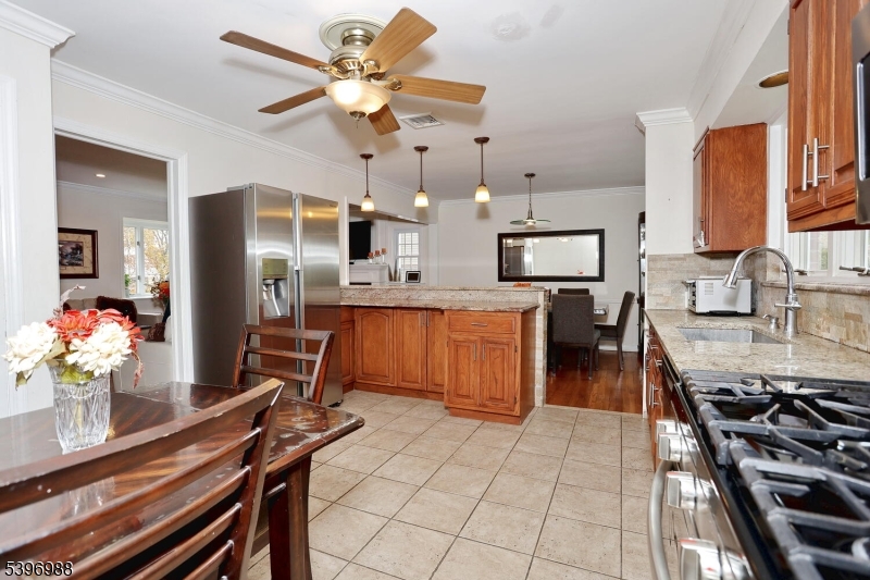 12 Pershing Avenue Ridgewood, NJ 07450 - Photo 15 of 42 a kitchen with stainless steel appliances a stove a chimney a dining table and chairs