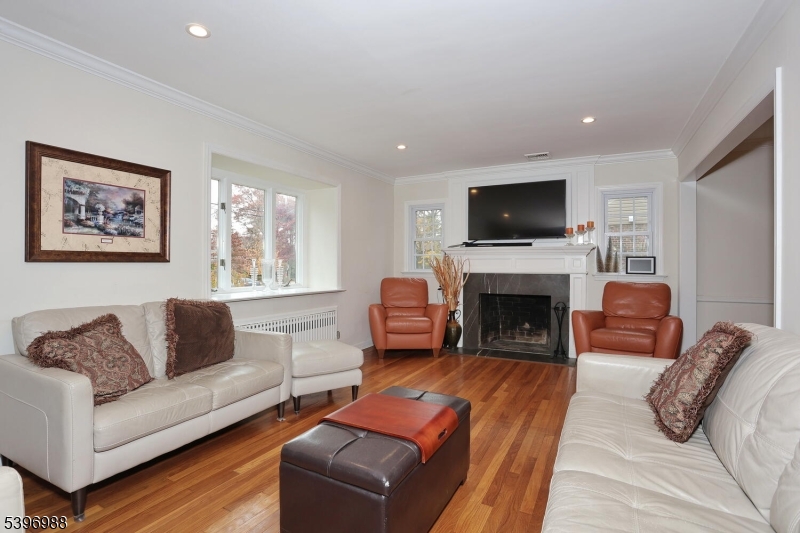 12 Pershing Avenue Ridgewood, NJ 07450 - Photo 8 of 42 a living room with furniture a flat screen tv and a fireplace