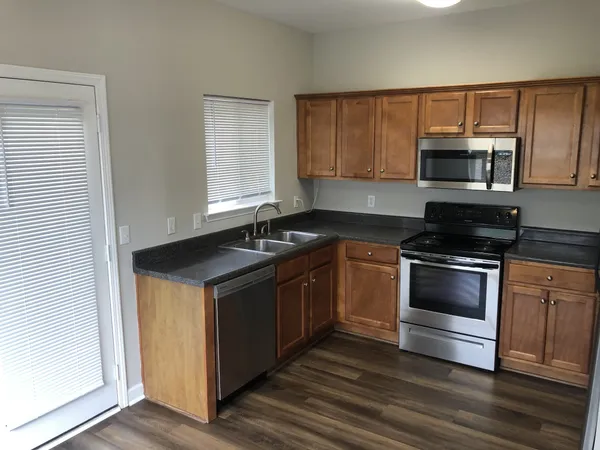 a kitchen with granite countertop a stove and a microwave