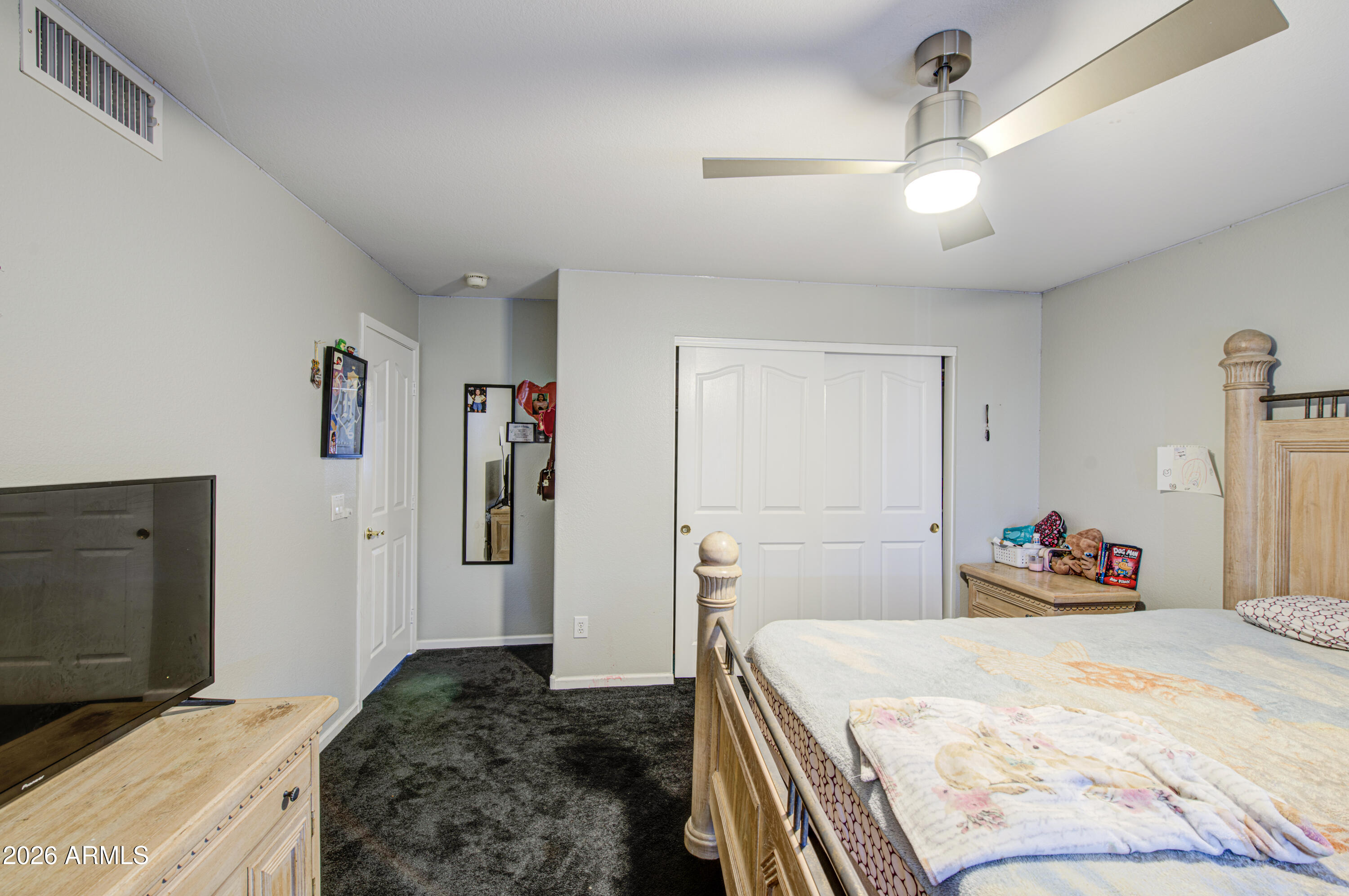 12403 West Monte Vista Road Avondale, AZ 85392 - Photo 41 of 63 a bedroom with a bed and a flat screen tv