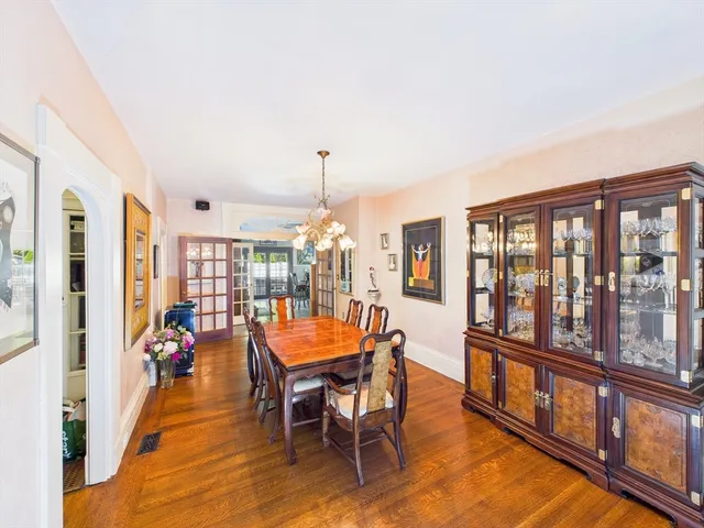 a view of a dining room with furniture a chandelier and wooden floor