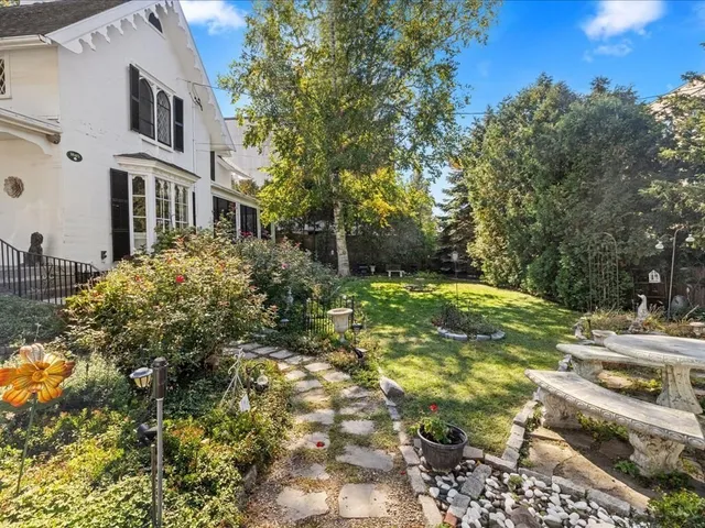 a view of a yard with plants and trees