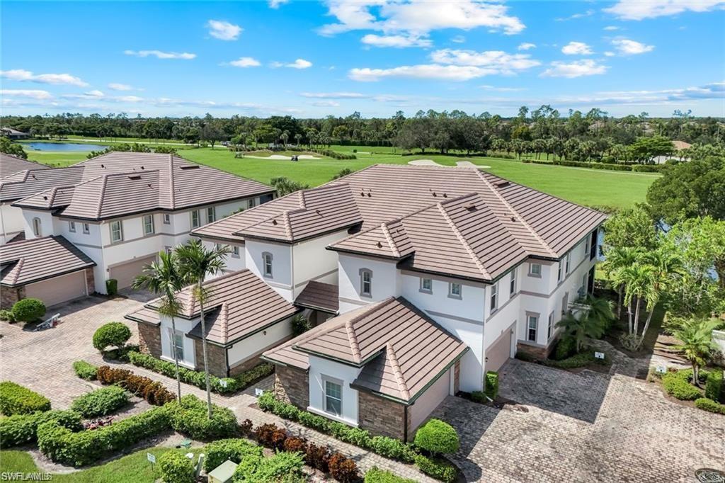 9525 Ironstone Terrace, Unit 102 Naples, FL 34120 - Photo 1 of 35 an aerial view of multiple houses with a yard