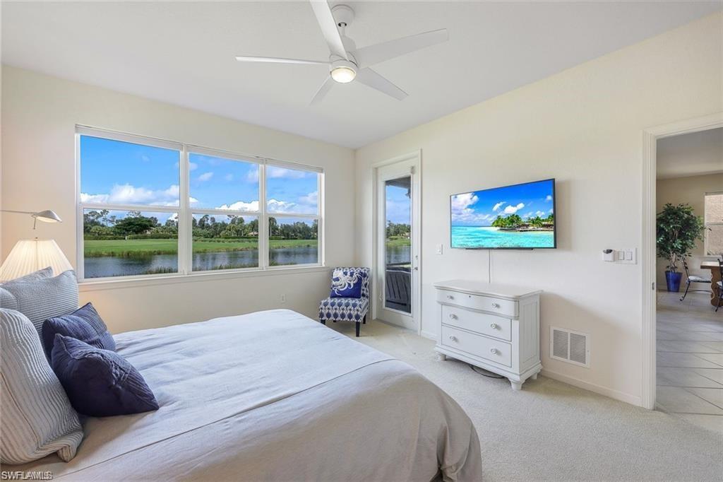 9525 Ironstone Terrace, Unit 102 Naples, FL 34120 - Photo 13 of 35 a spacious bedroom with a bed and a flat screen tv