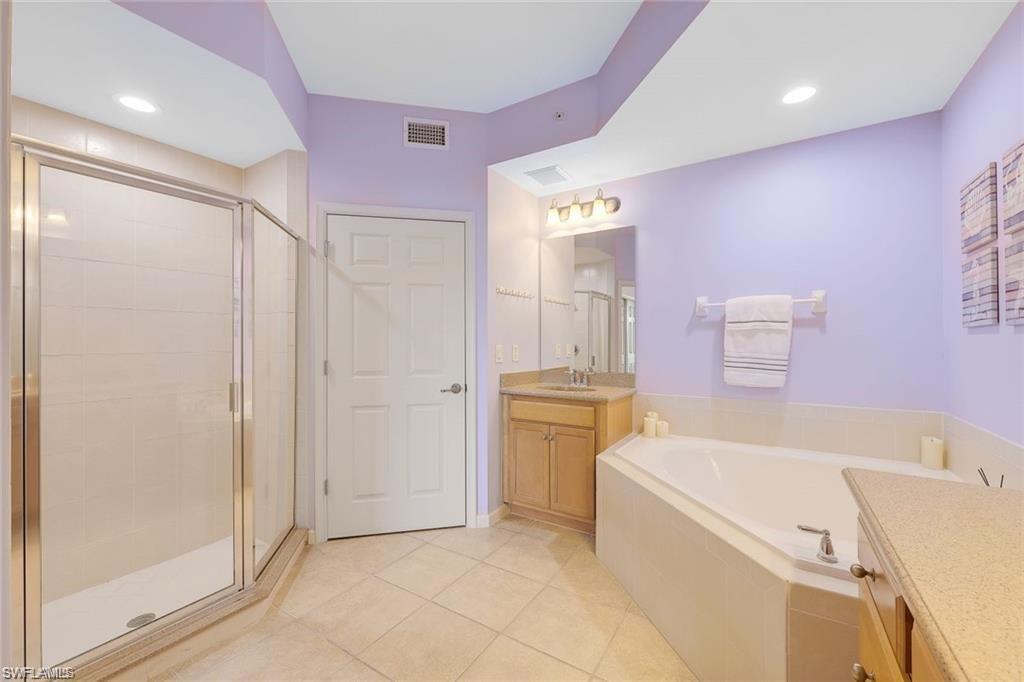 9525 Ironstone Terrace, Unit 102 Naples, FL 34120 - Photo 15 of 35 a bathroom with a tub sink and a mirror