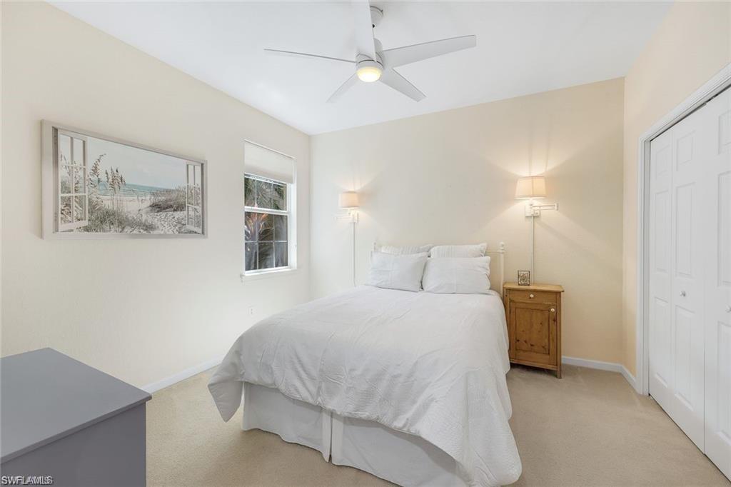 9525 Ironstone Terrace, Unit 102 Naples, FL 34120 - Photo 16 of 35 a bedroom with a bed and a chandelier