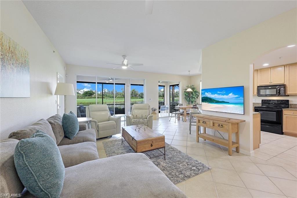 9525 Ironstone Terrace, Unit 102 Naples, FL 34120 - Photo 3 of 35 a living room with fireplace furniture and a large window