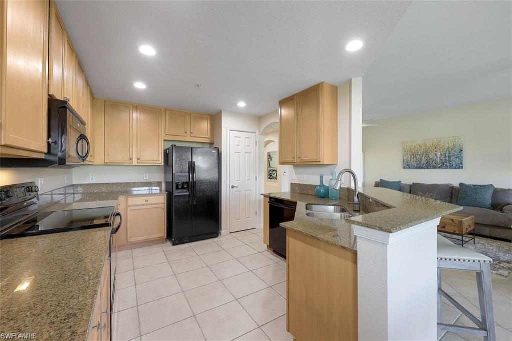 9525 Ironstone Terrace, Unit 102 Naples, FL 34120 - Photo 9 of 35 a kitchen with a stove a refrigerator and a sink
