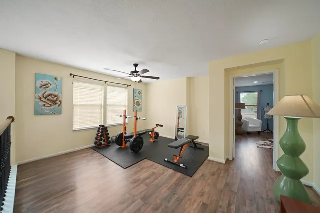 a living room with furniture gym equipment and a large window