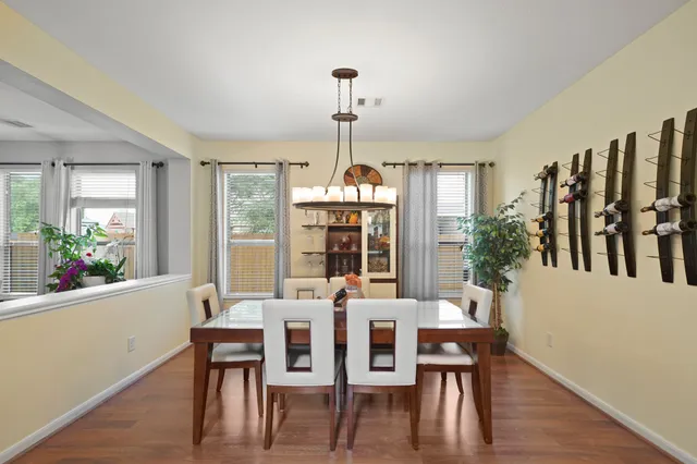 a dining room with furniture a chandelier and wooden floor
