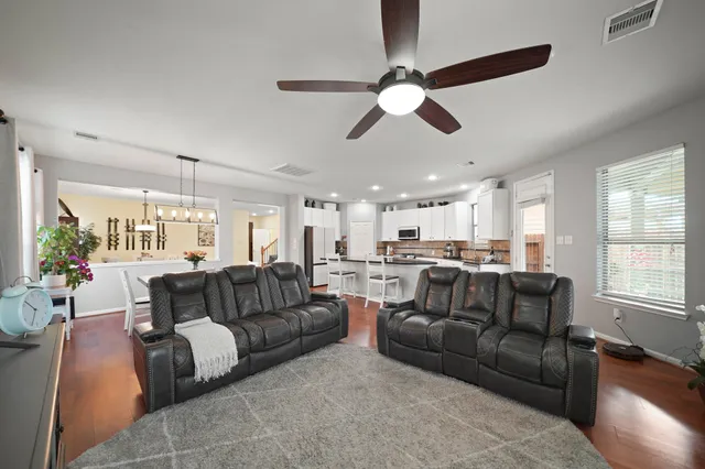 a living room with furniture ceiling fan and a window