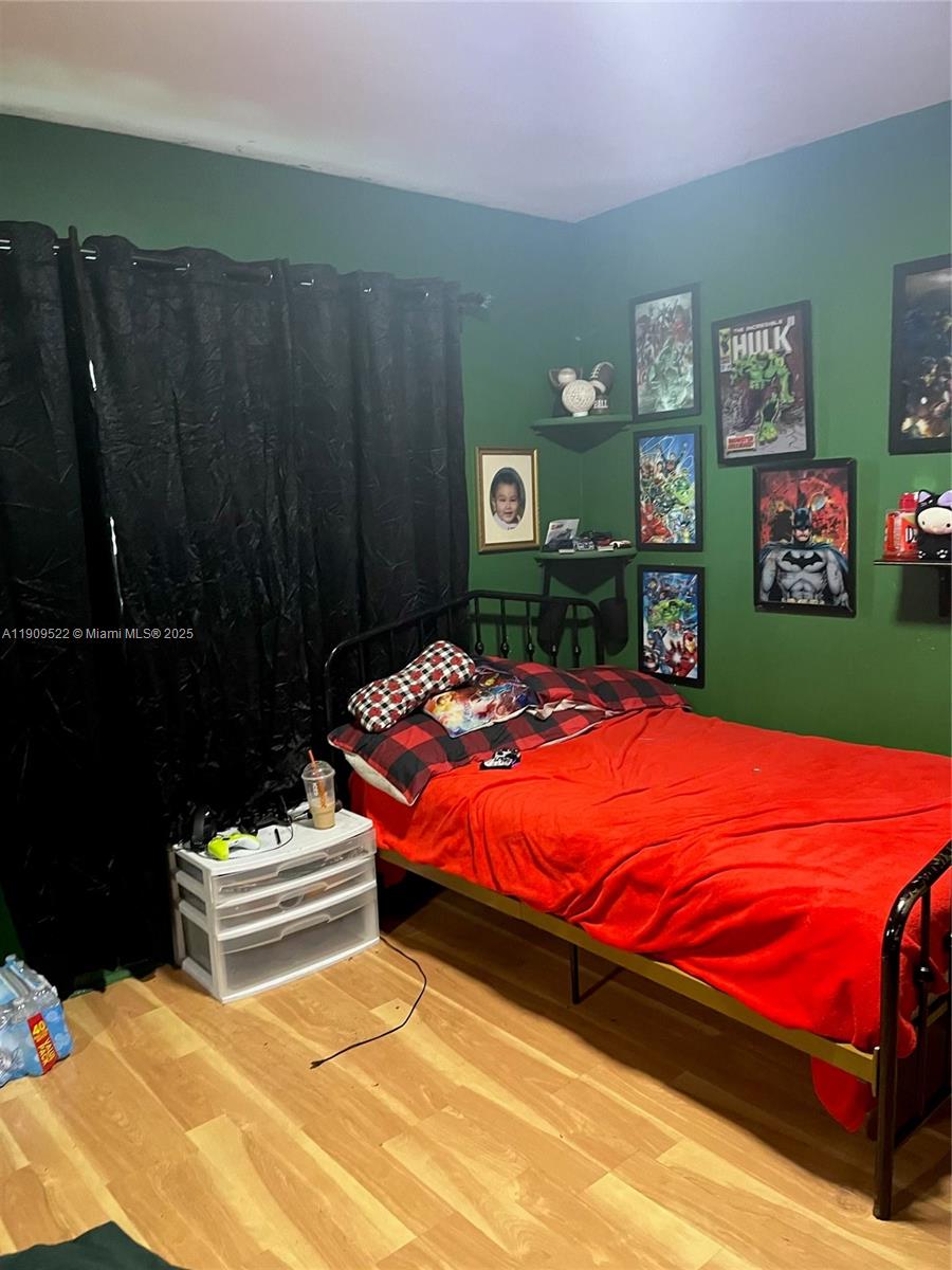 6221 Southwest 26th Street Miramar, FL 33023 - Photo 6 of 12 a bedroom with a bed and wooden floor