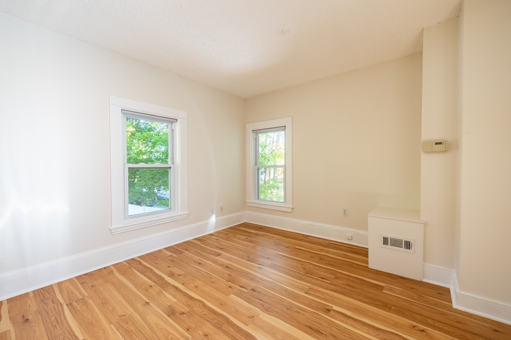 365 Whiting Avenue, Unit 2 Dedham, MA 02026 - Photo 11 of 15 an empty room with wooden floor and windows