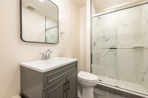 a bathroom with a sink a toilet and shower