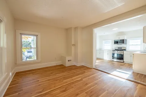 a view of a kitchen with wooden floor and a window