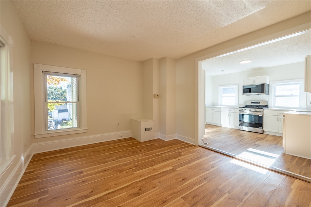 365 Whiting Avenue, Unit 2 Dedham, MA 02026 - Photo 8 of 15 a view of a kitchen with wooden floor and a window