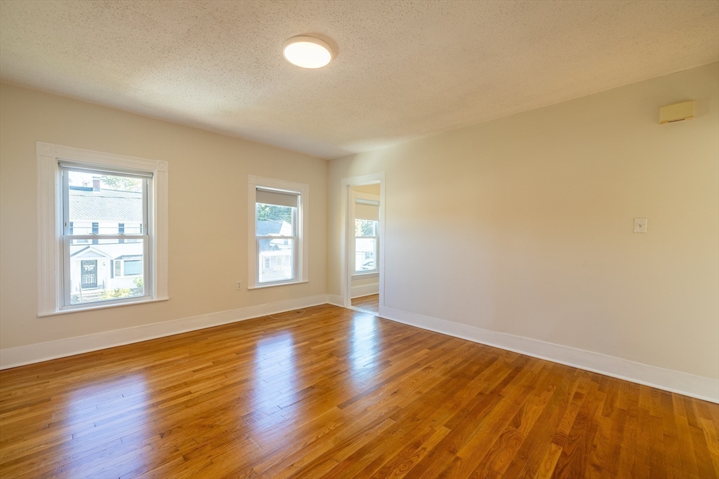 365 Whiting Avenue, Unit 2 Dedham, MA 02026 - Photo 10 of 15 a view of an empty room with wooden floor and a window