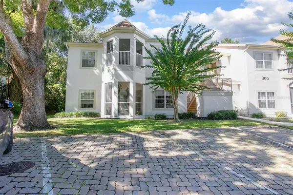 a front view of a house with a yard and trees