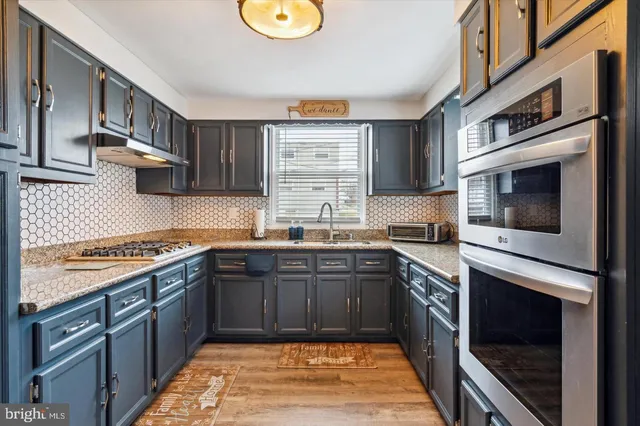 a kitchen with stainless steel appliances granite countertop a stove microwave and sink