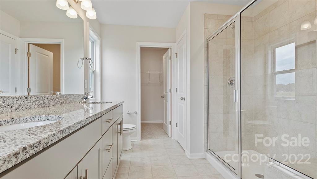 70 Creekview Road Hendersonville, NC 28792 - Photo 24 of 27 a bathroom with a granite countertop sink a mirror and a shower