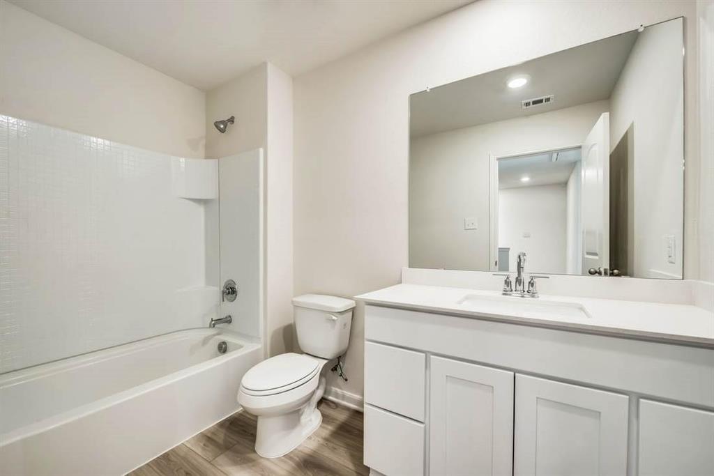 1226 Parker Drive Princeton, TX 75407 - Photo 19 of 35 Bathroom featuring tub / shower combination, wood finished floors, and vanity