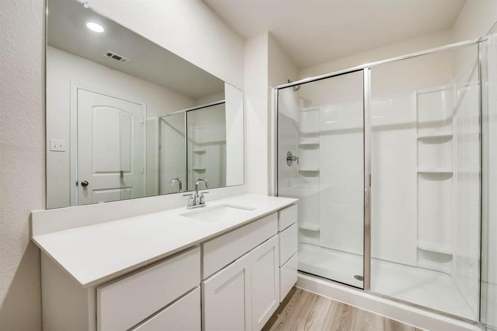 1226 Parker Drive Princeton, TX 75407 - Photo 20 of 35 Bathroom with vanity, a stall shower, and light wood-style flooring