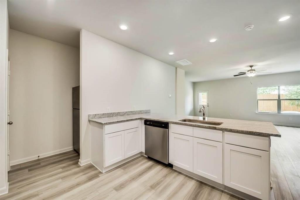 1226 Parker Drive Princeton, TX 75407 - Photo 4 of 35 Kitchen featuring a peninsula, white cabinets, stainless steel dishwasher, light wood finished floors, and recessed lighting