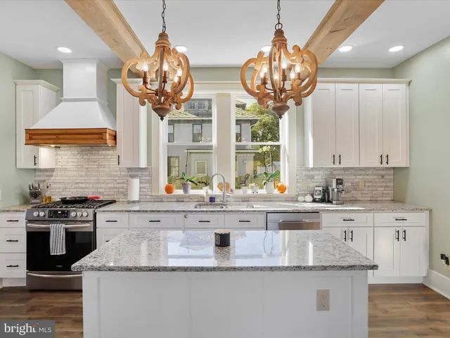 a kitchen with stainless steel appliances granite countertop a stove a refrigerator and a wooden cabinets