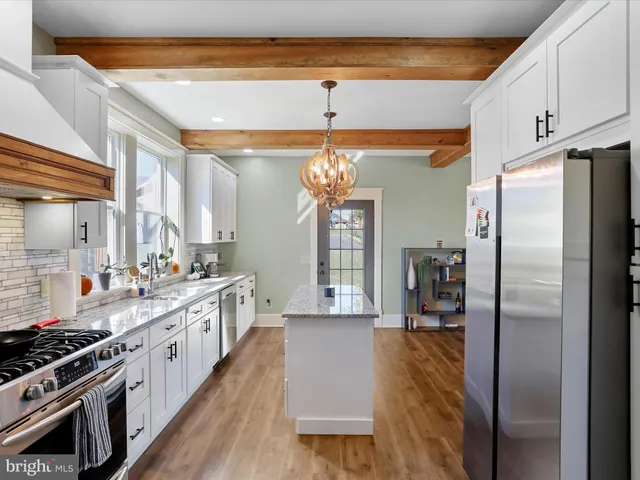 a kitchen with stainless steel appliances granite countertop a refrigerator and a stove top oven