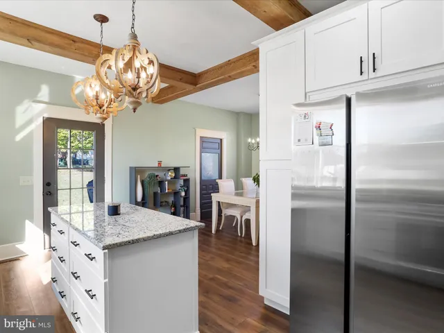 a kitchen with a sink a chandelier and living room view